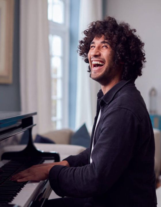 young-man-sitting-at-grand-piano-and-playing-at-ho-2021-08-30-06-14-52-utc-e1697687758956.jpg
